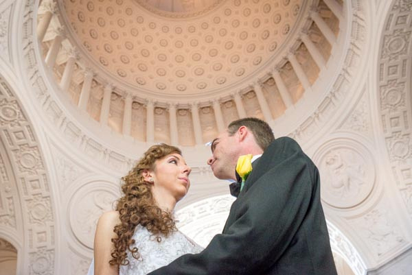 Bride and groom looking into each other's eyes after wedding elopement ceremony with dome ceiling in background at San Francisco City Hall.